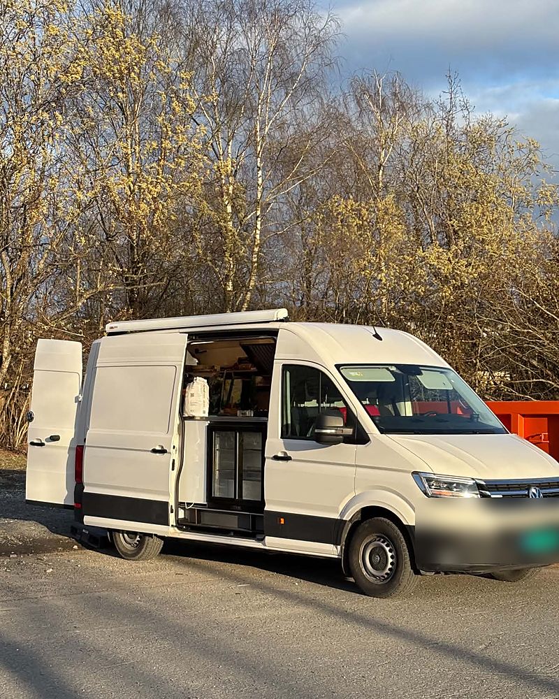Trucken i dagslys med sidedøren åpen og kjøledisken synlig.